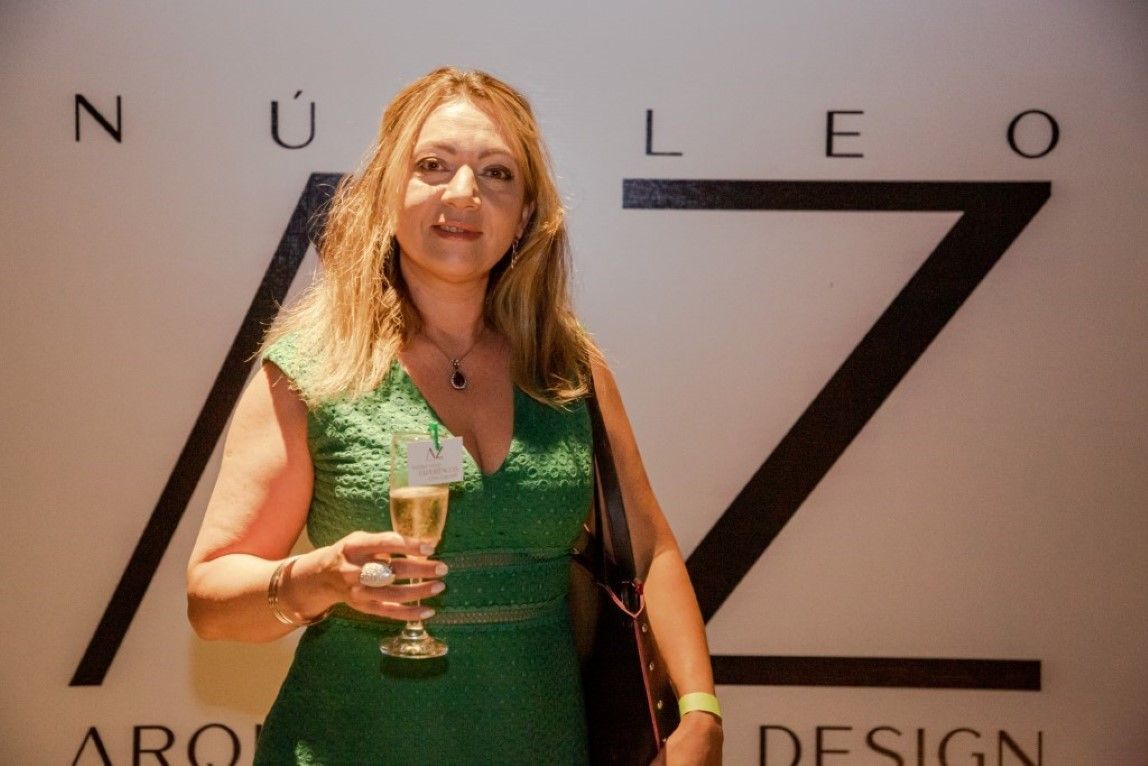 Uma mulher de vestido verde segura uma taça de champanhe