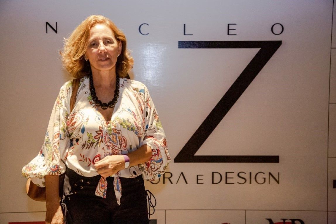 Uma mulher está em frente a uma placa que diz cleo