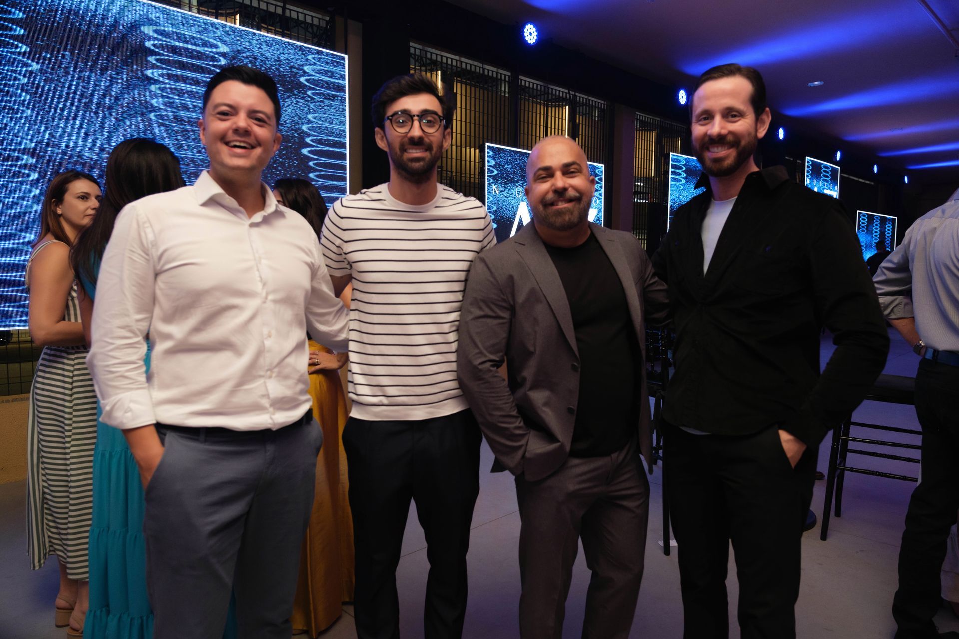 Um grupo de homens está posando para uma foto em uma festa.