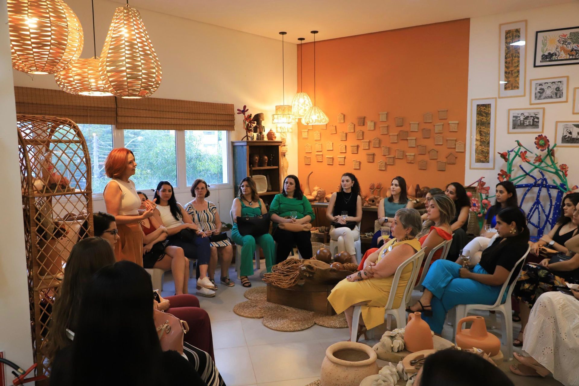 Um grupo de mulheres está sentado em círculo em uma sala.