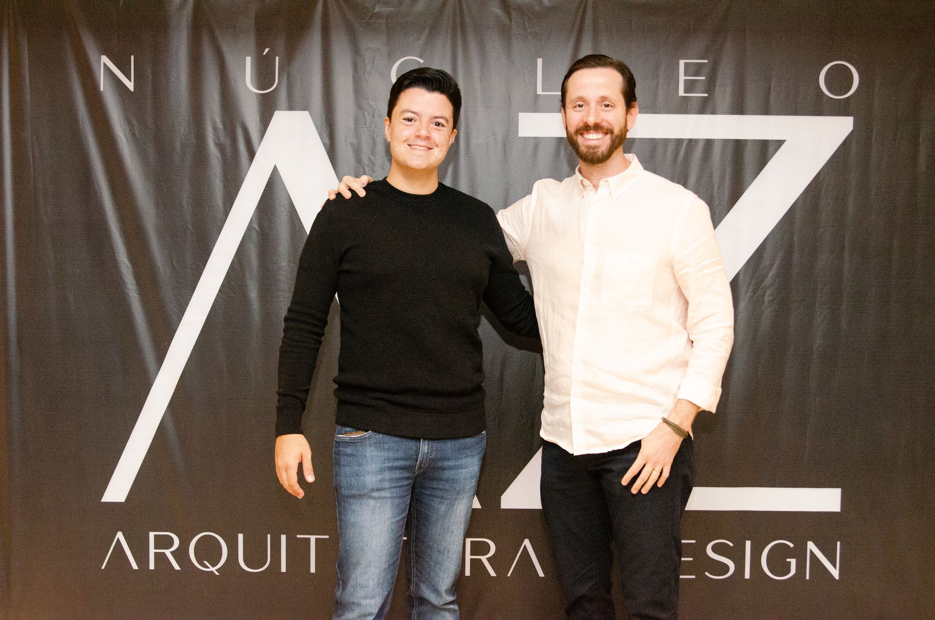 Dois homens em pé na frente de uma placa que diz arquiteta design