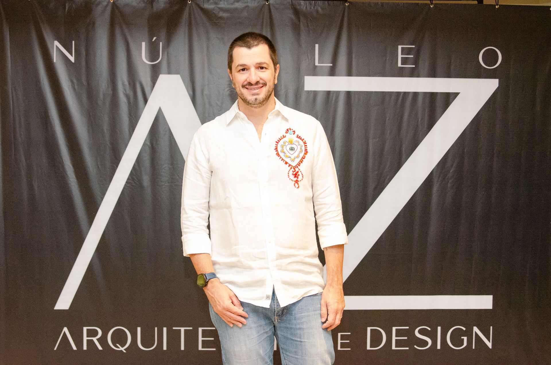 Um homem está em frente a uma placa que diz arquitete design