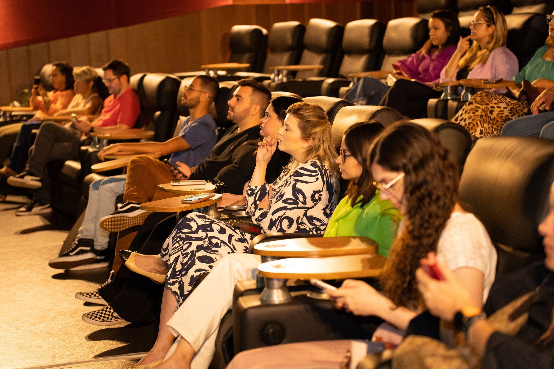 Um grupo de pessoas está sentado em um cinema assistindo a um filme.