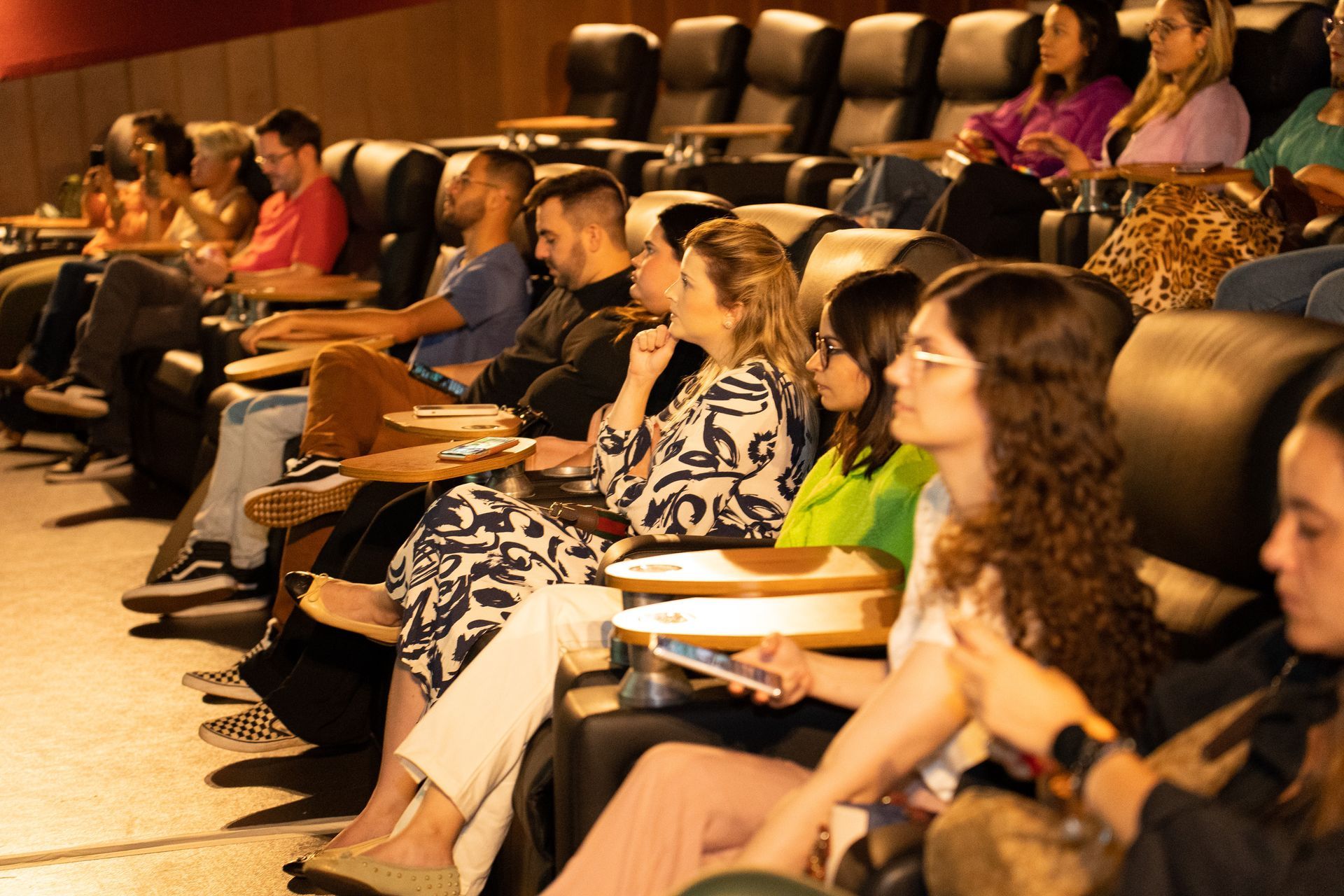 Um grupo de pessoas está sentado em um cinema assistindo a um filme.