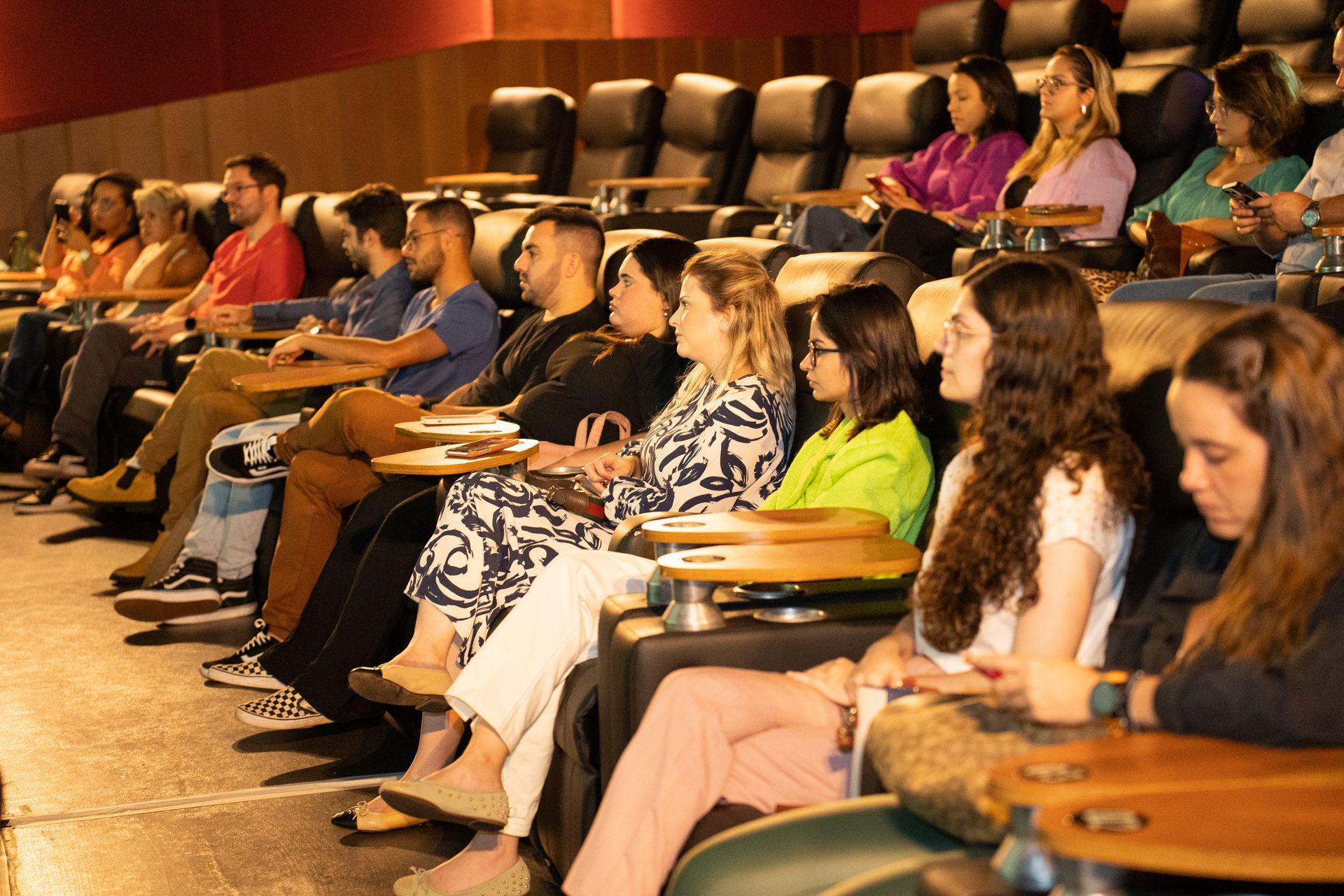 Um grupo de pessoas está sentado em um cinema assistindo a um filme.