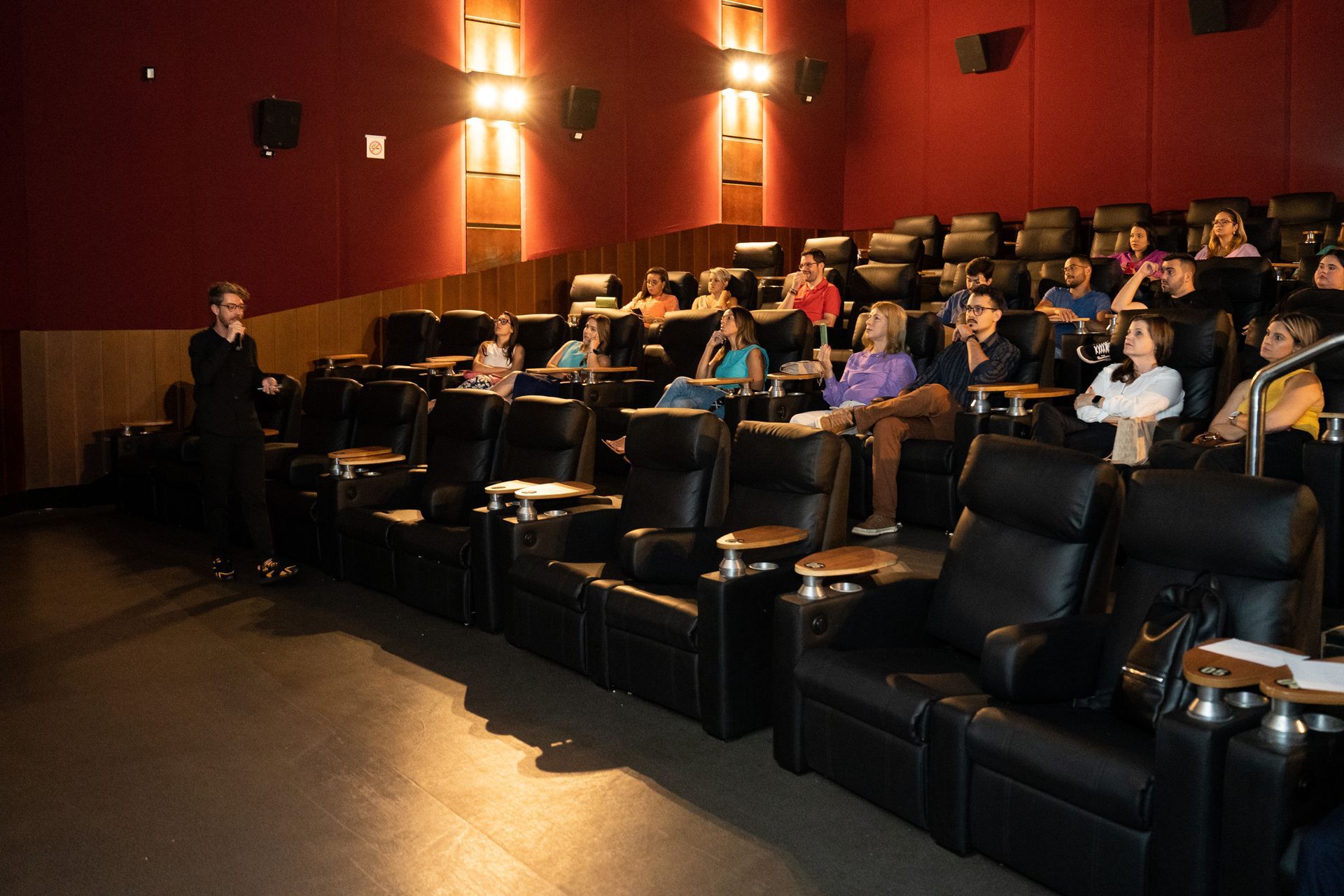 Um grupo de pessoas está sentado em um cinema assistindo a um filme.