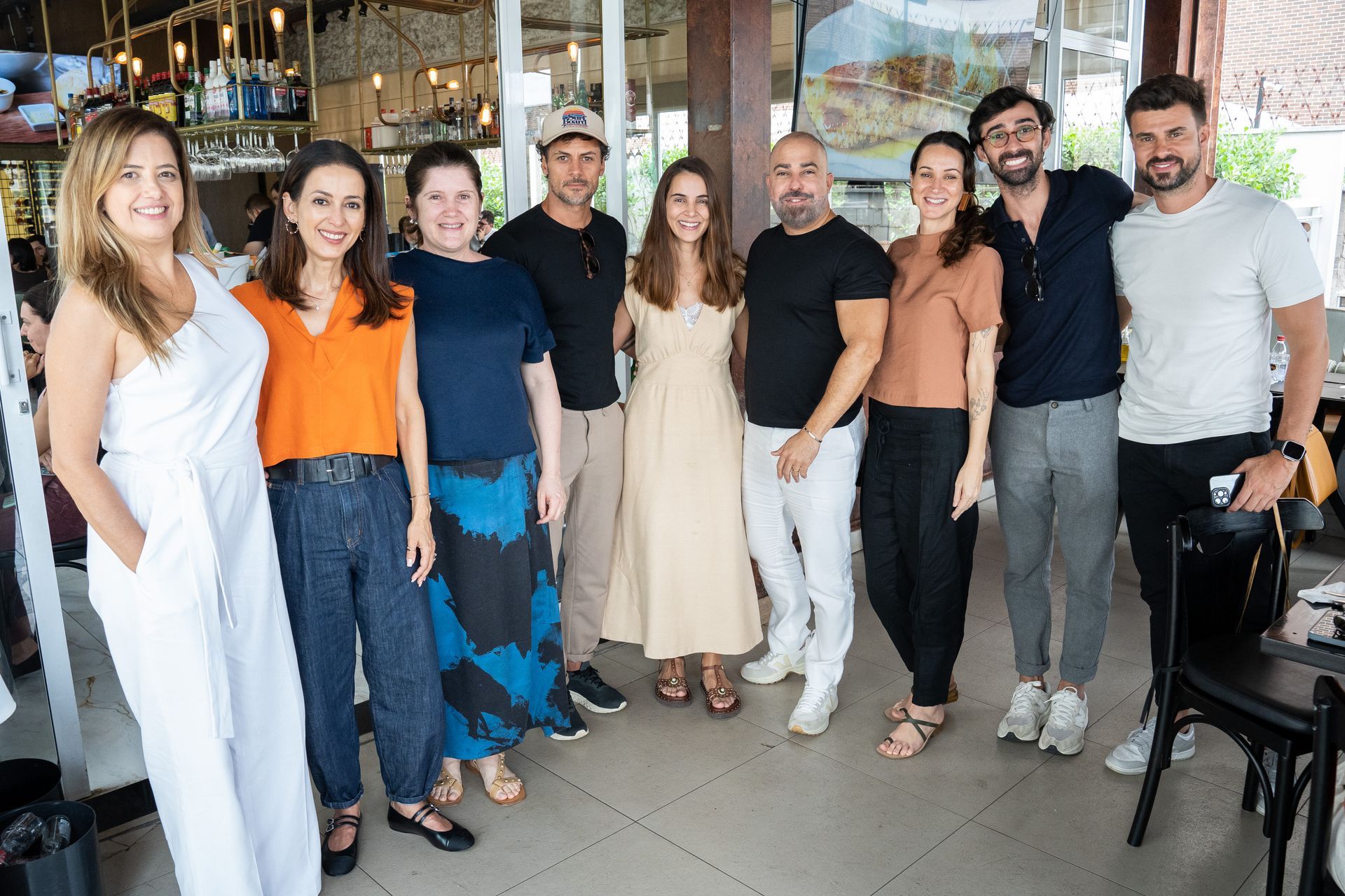 Um grupo de pessoas está posando para uma foto em um restaurante.
