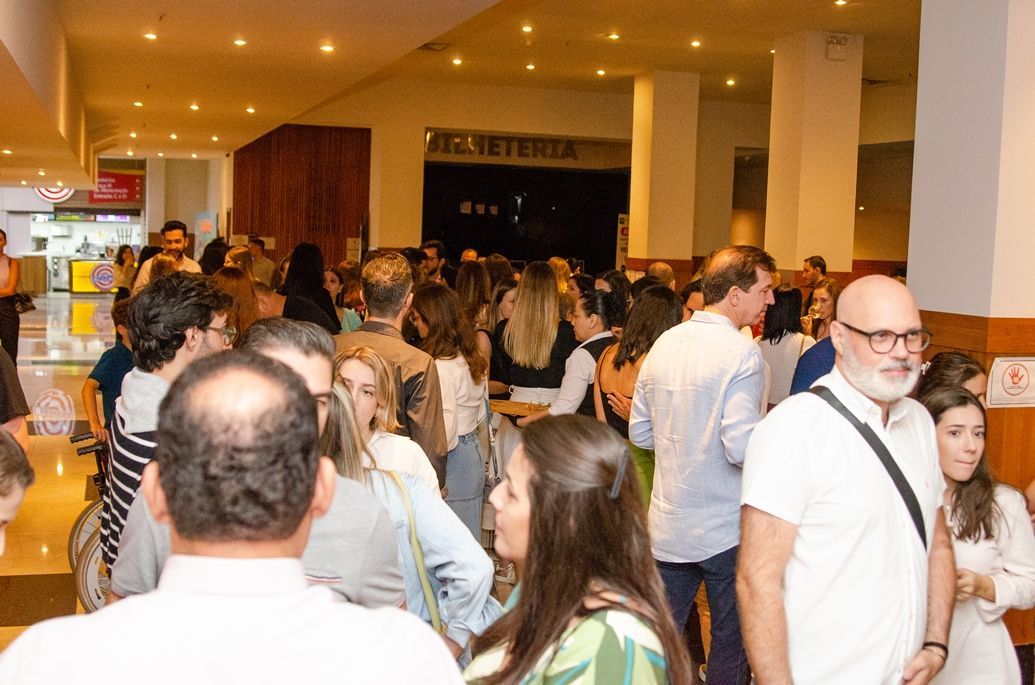 Um grande grupo de pessoas está em pé em uma sala.