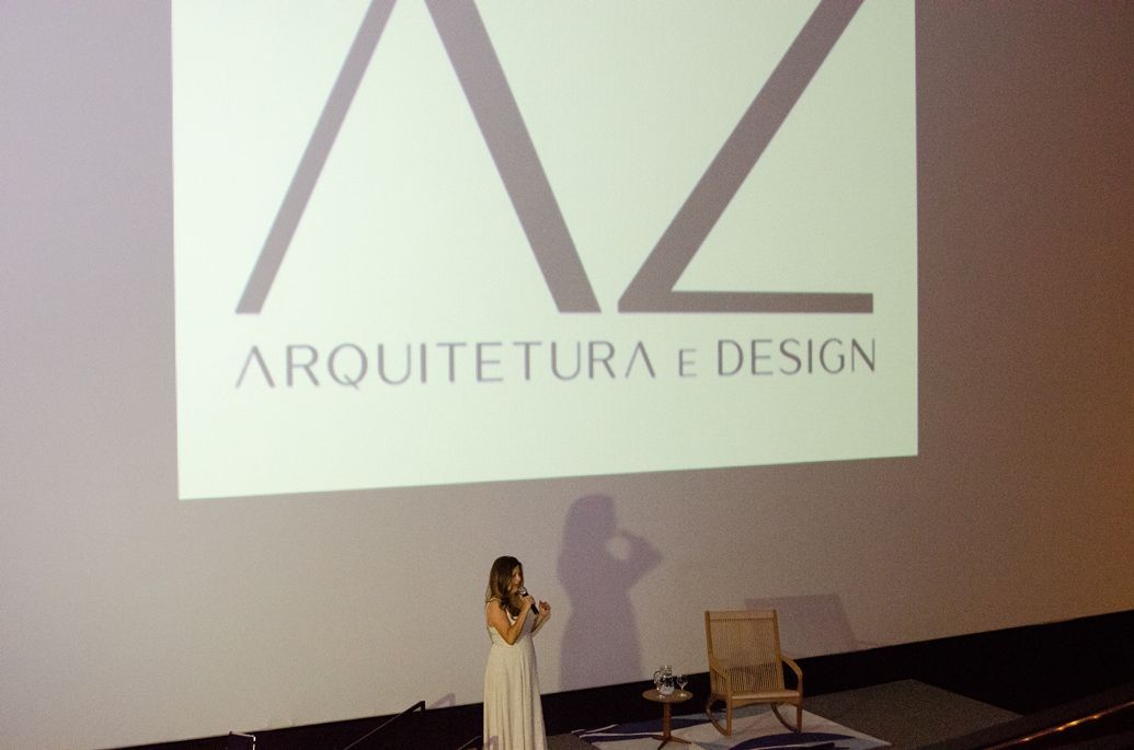 Uma mulher está em frente a uma tela grande que diz arquitetura e design