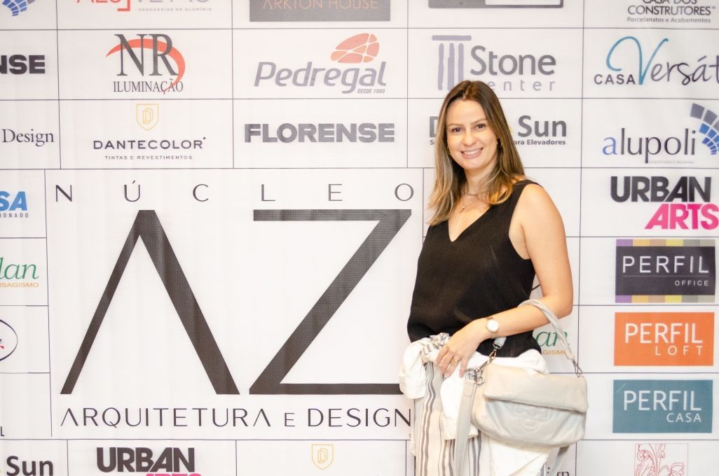 Uma mulher está parada em frente a uma parede que diz az