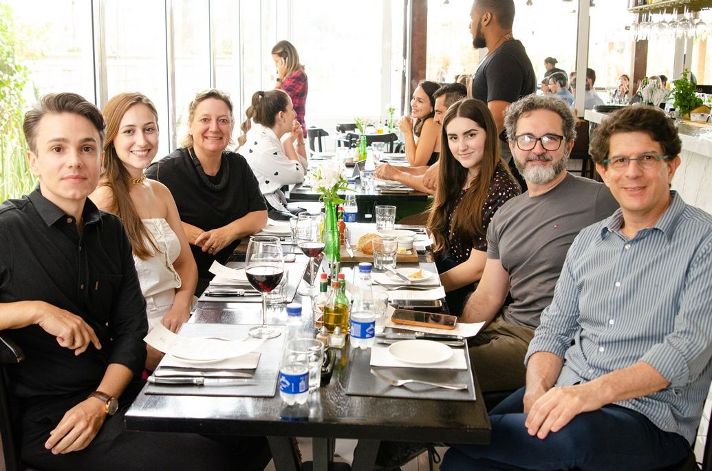 Um grupo de pessoas está sentado à mesa em um restaurante.