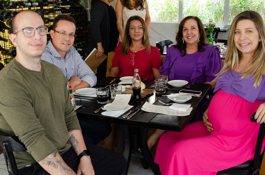 Um grupo de pessoas está sentado à mesa em um restaurante.