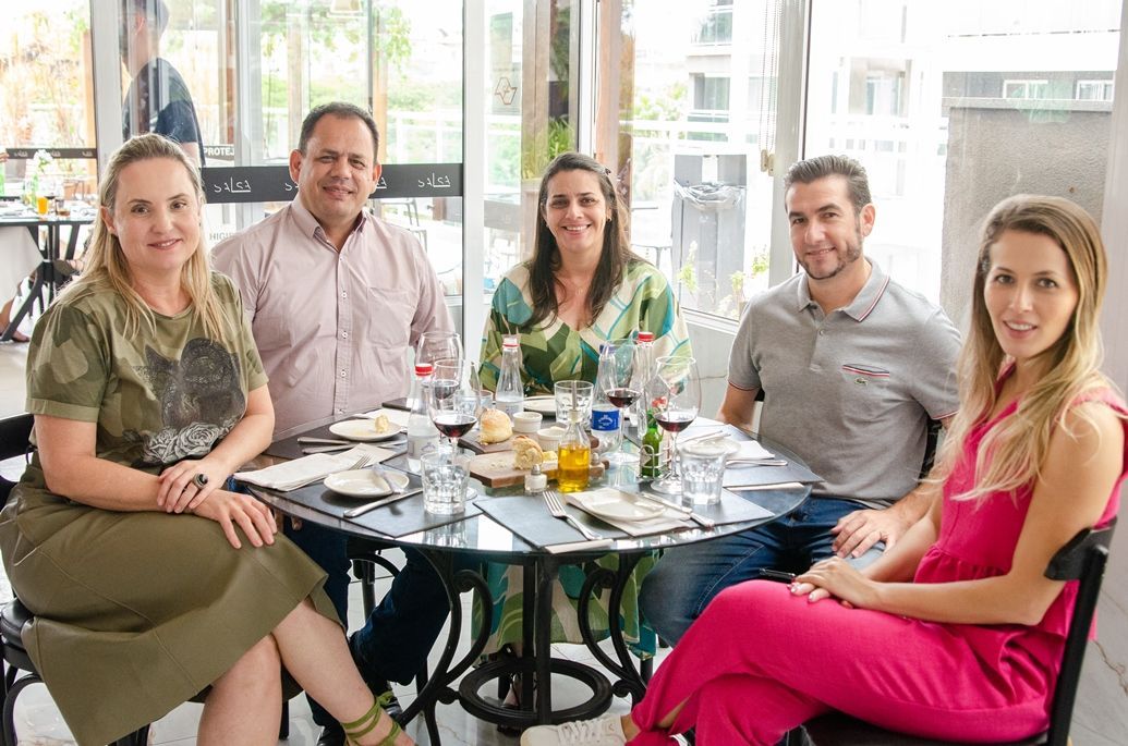 Um grupo de pessoas está sentado ao redor de uma mesa em um restaurante.