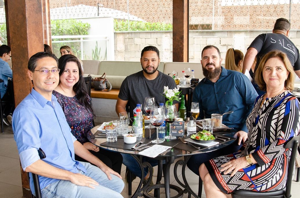 Um grupo de pessoas está sentado à mesa em um restaurante.