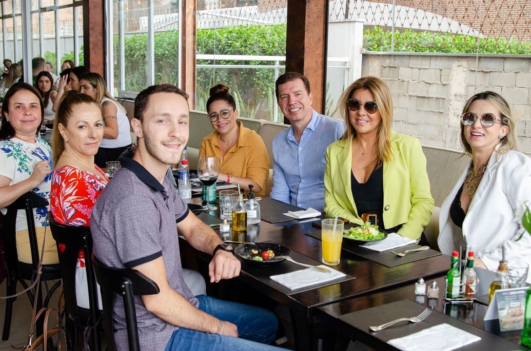 Um grupo de pessoas está sentado à mesa em um restaurante.