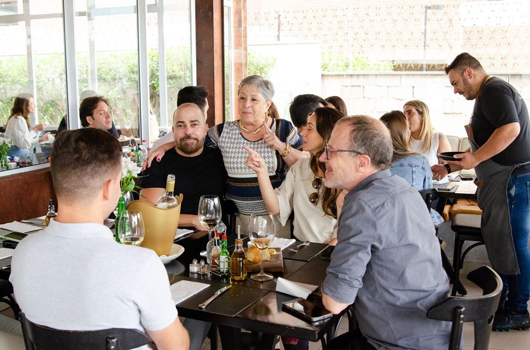 Um grupo de pessoas está sentado em mesas em um restaurante.
