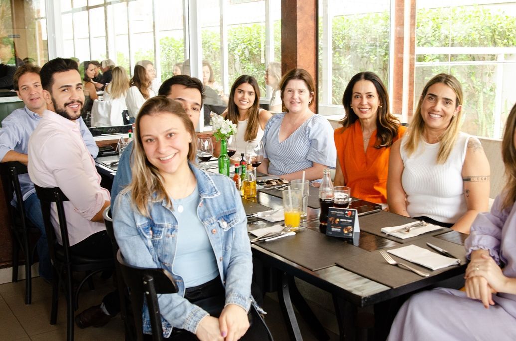 Um grupo de pessoas está sentado em mesas em um restaurante.