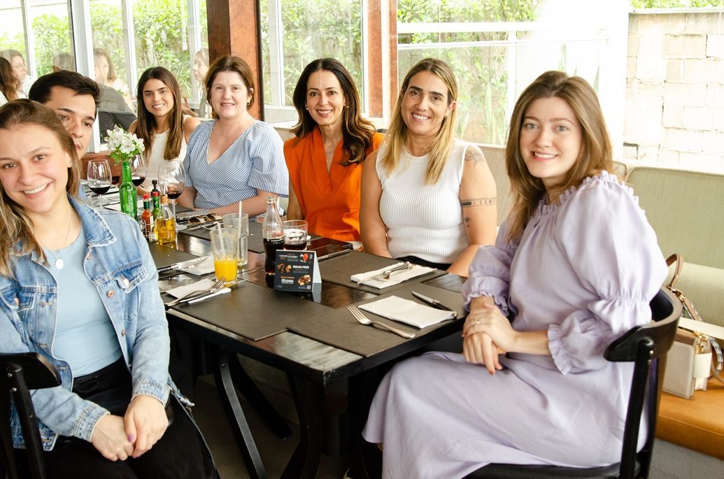 Um grupo de pessoas está sentado à mesa em um restaurante.