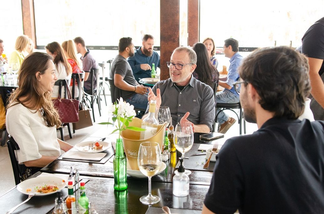 Um grupo de pessoas está sentado à mesa em um restaurante.