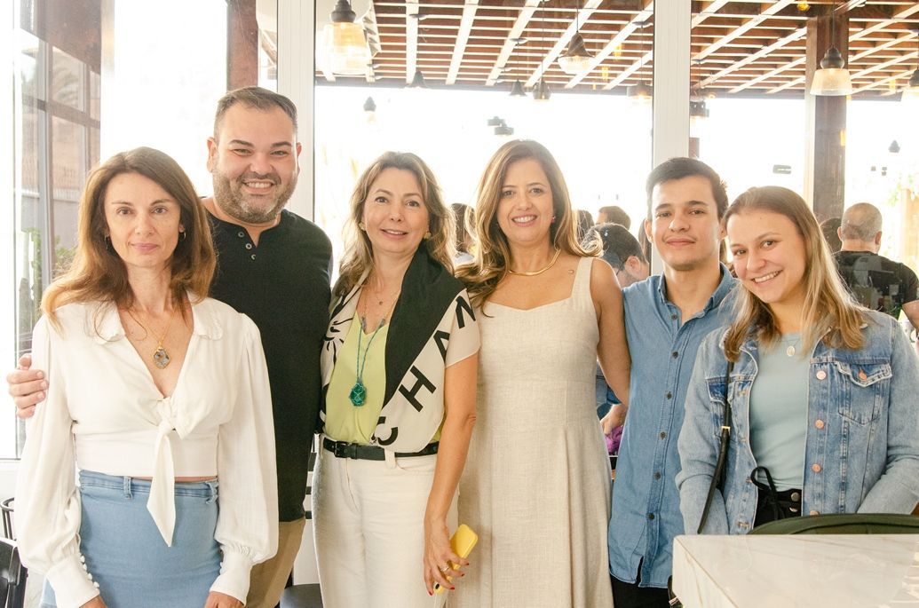 Um grupo de pessoas está posando para uma foto juntas em uma sala.