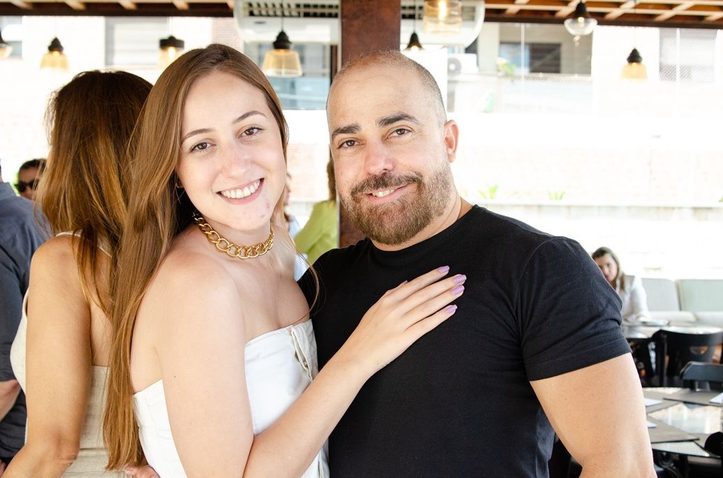 Um homem e uma mulher estão posando para uma foto em um restaurante.