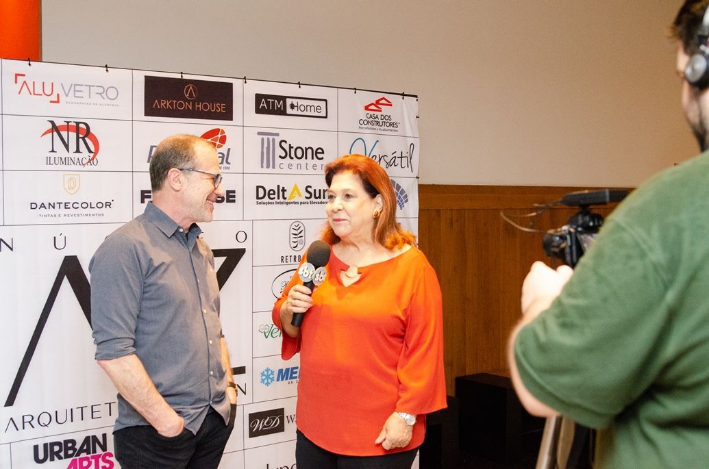 Um homem e uma mulher estão sendo entrevistados por um cinegrafista