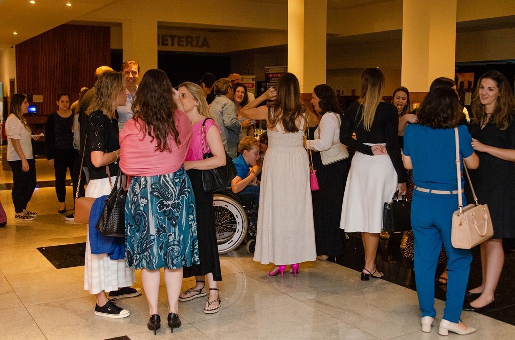 Um grupo de mulheres estão em uma sala conversando entre si.