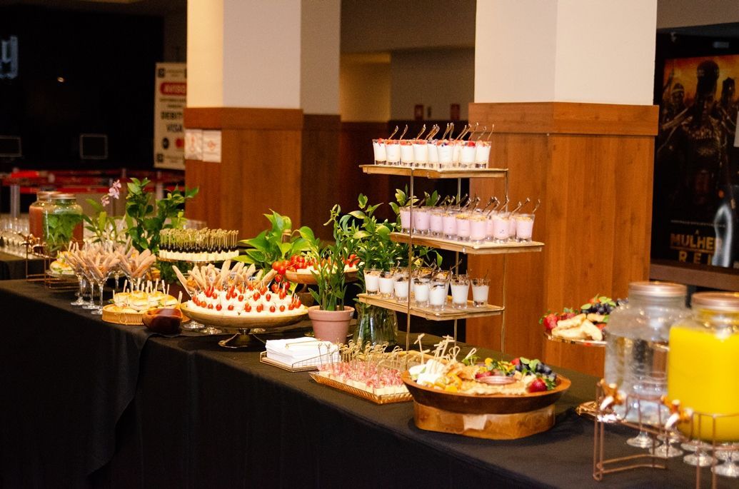 Uma mesa de bufê com uma variedade de comidas e bebidas.