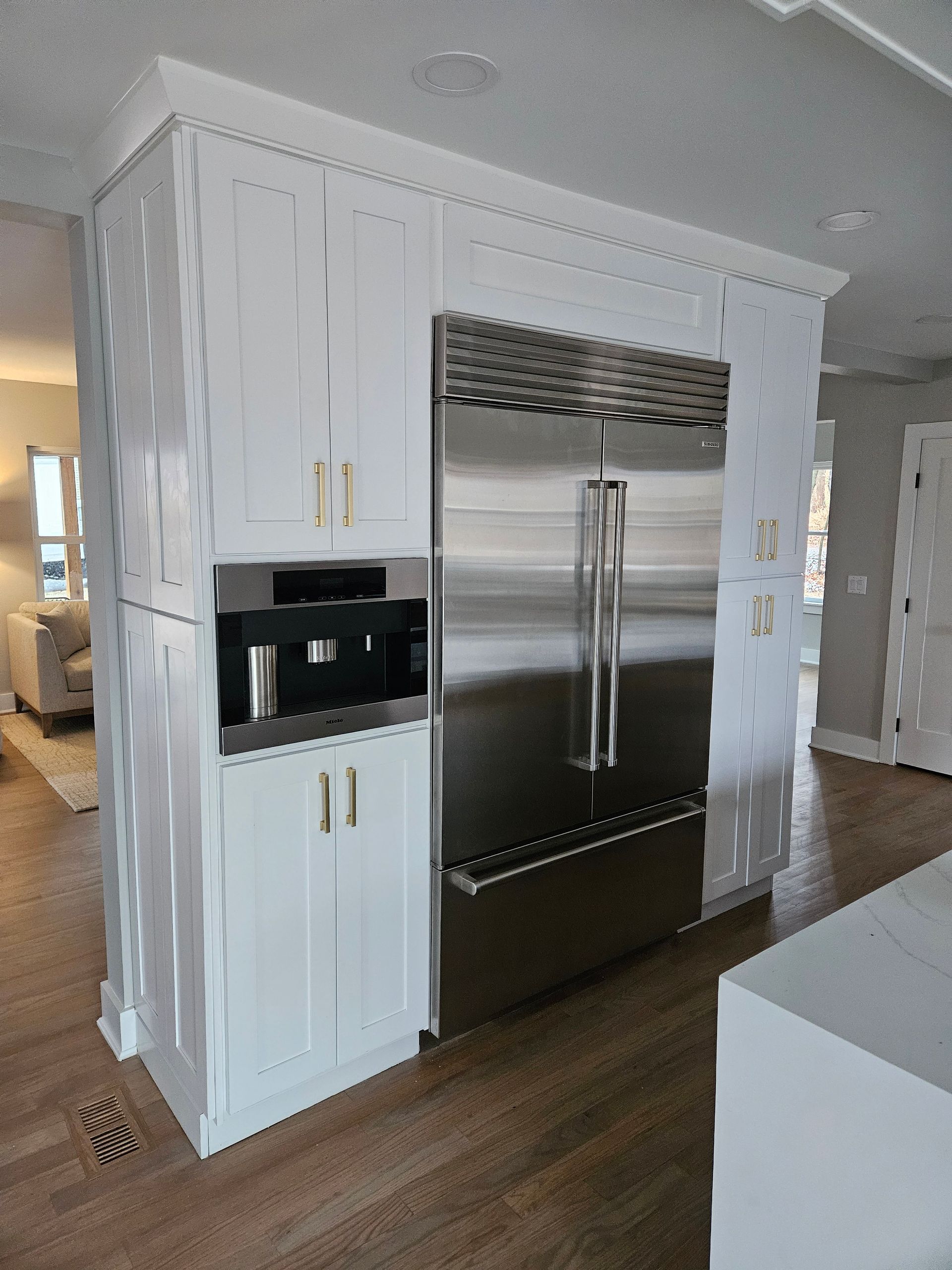 Hand opening a stainless steel refrigerator door, revealing interior shelves and egg holder.