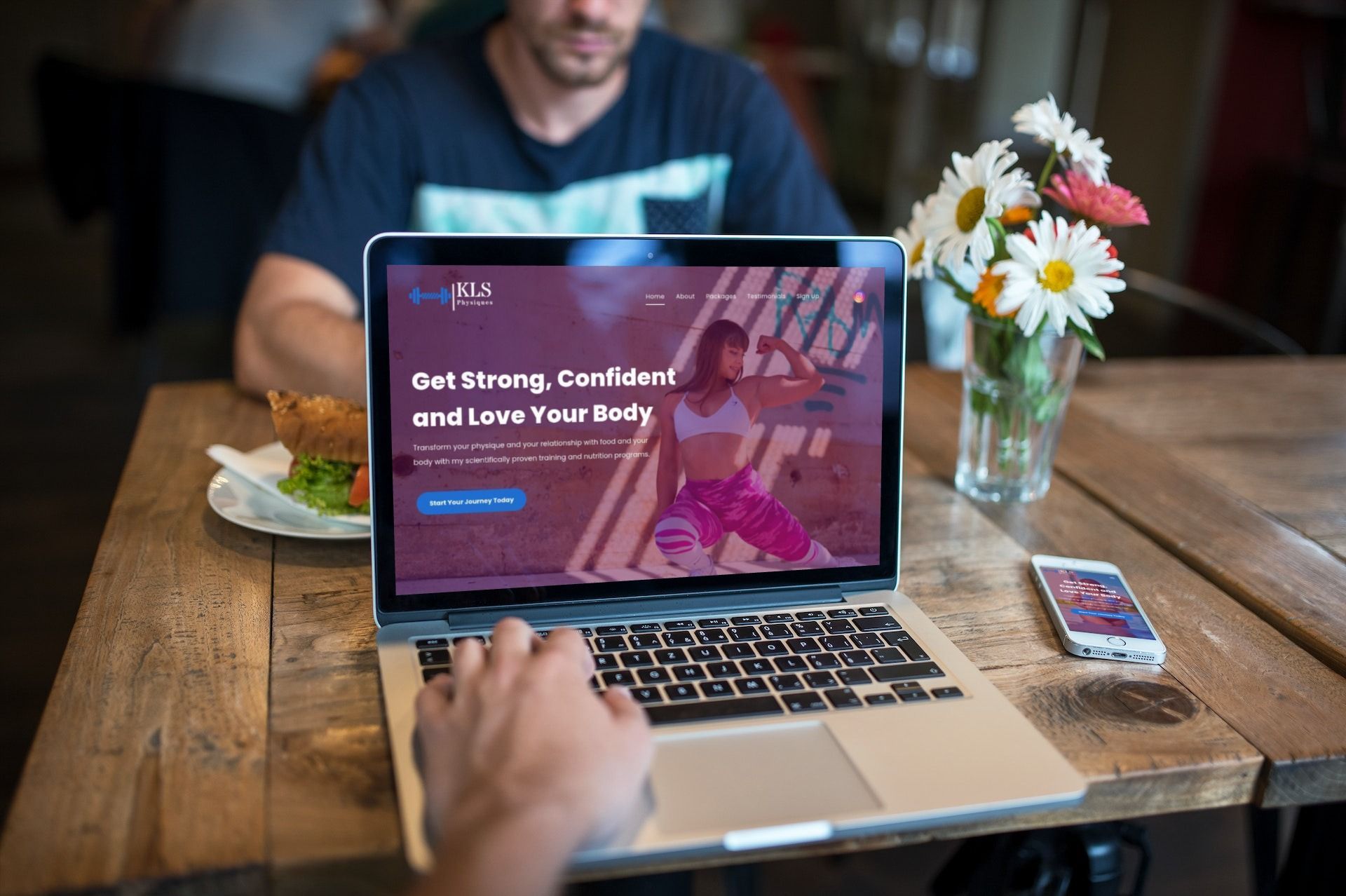 a man is sitting at a table using a laptop computer .