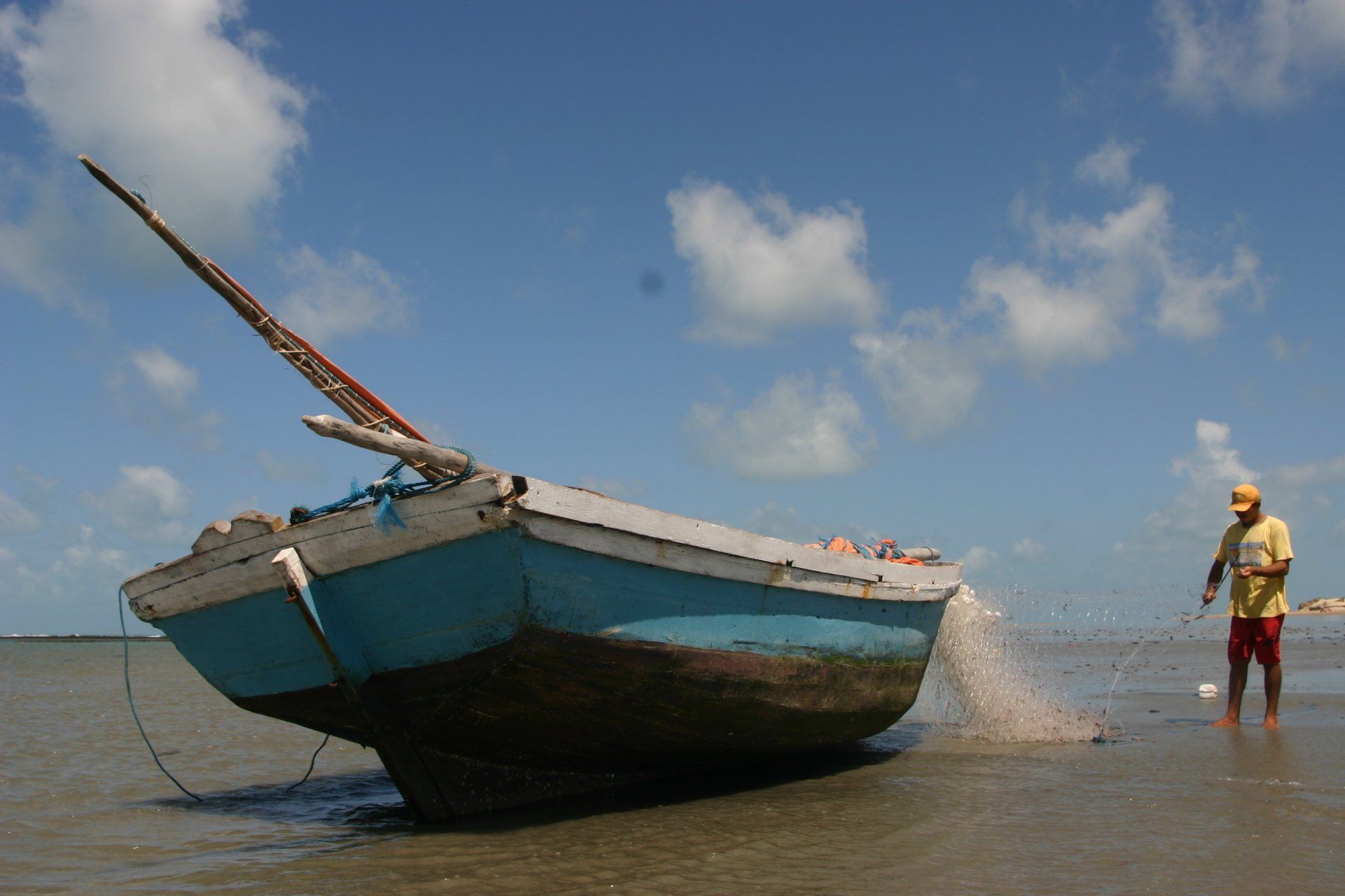 Um homem está parado ao lado de um barco na água