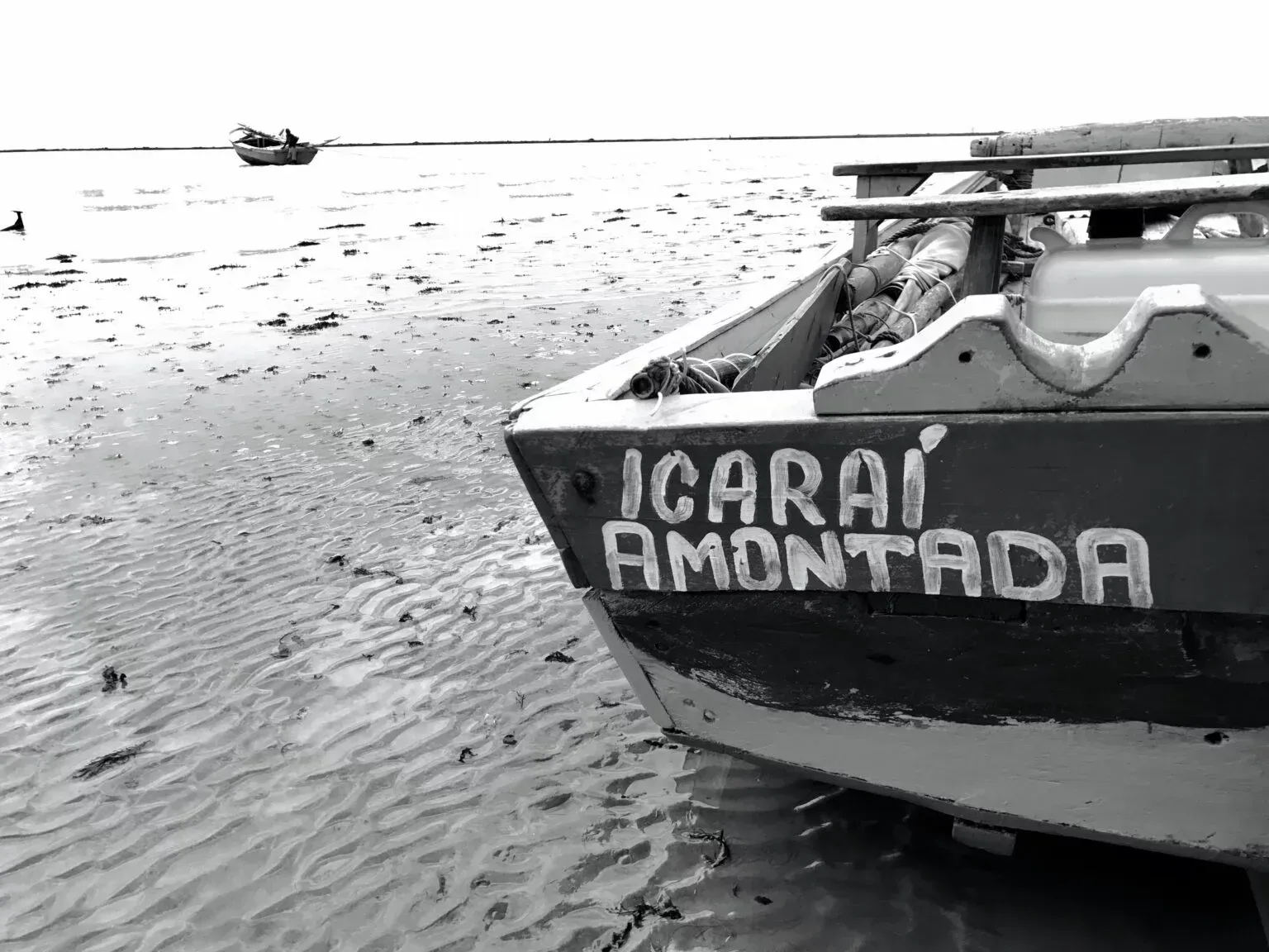 Uma foto em preto e branco de um barco que diz icarai amontoda