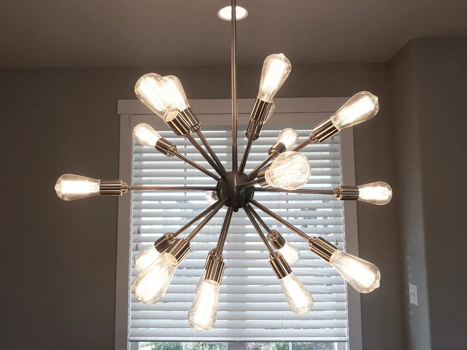 Modern chandelier with Edison-style bulbs hanging from a ceiling.