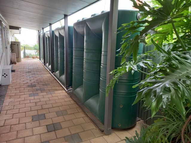 A Black Water Tank Is On The Roof Of A Building With A View Of The Ocean — Bennett's Environmental In Wollongong, NSW