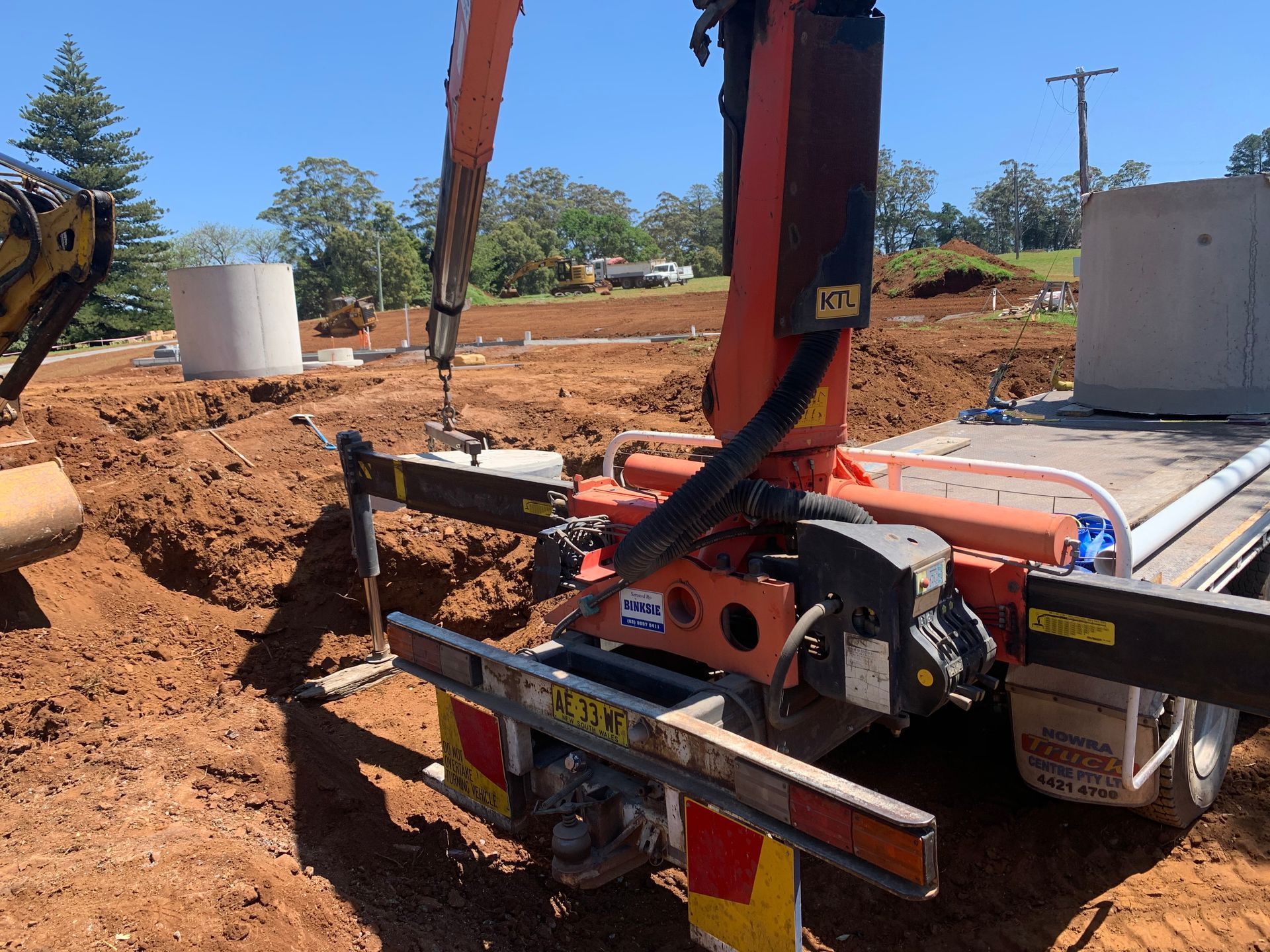 Orange Crane Carrying A Concrete Septic Tank — Bennett's Environmental In Shellharbour, NSW