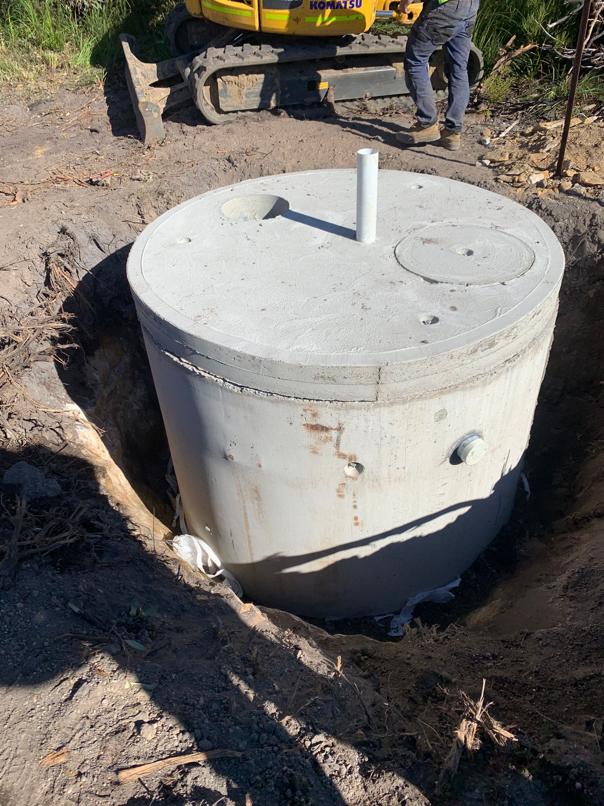 A Concrete Septic Tank Sitting In Hole In Dirt — Bennett's Environmental In Southern Highlands, NSW