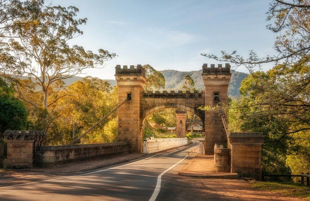 A Bridge Over A Road Surrounded By Trees And Mountains — Bennett's Environmental In Kangaroo Valley, NSW