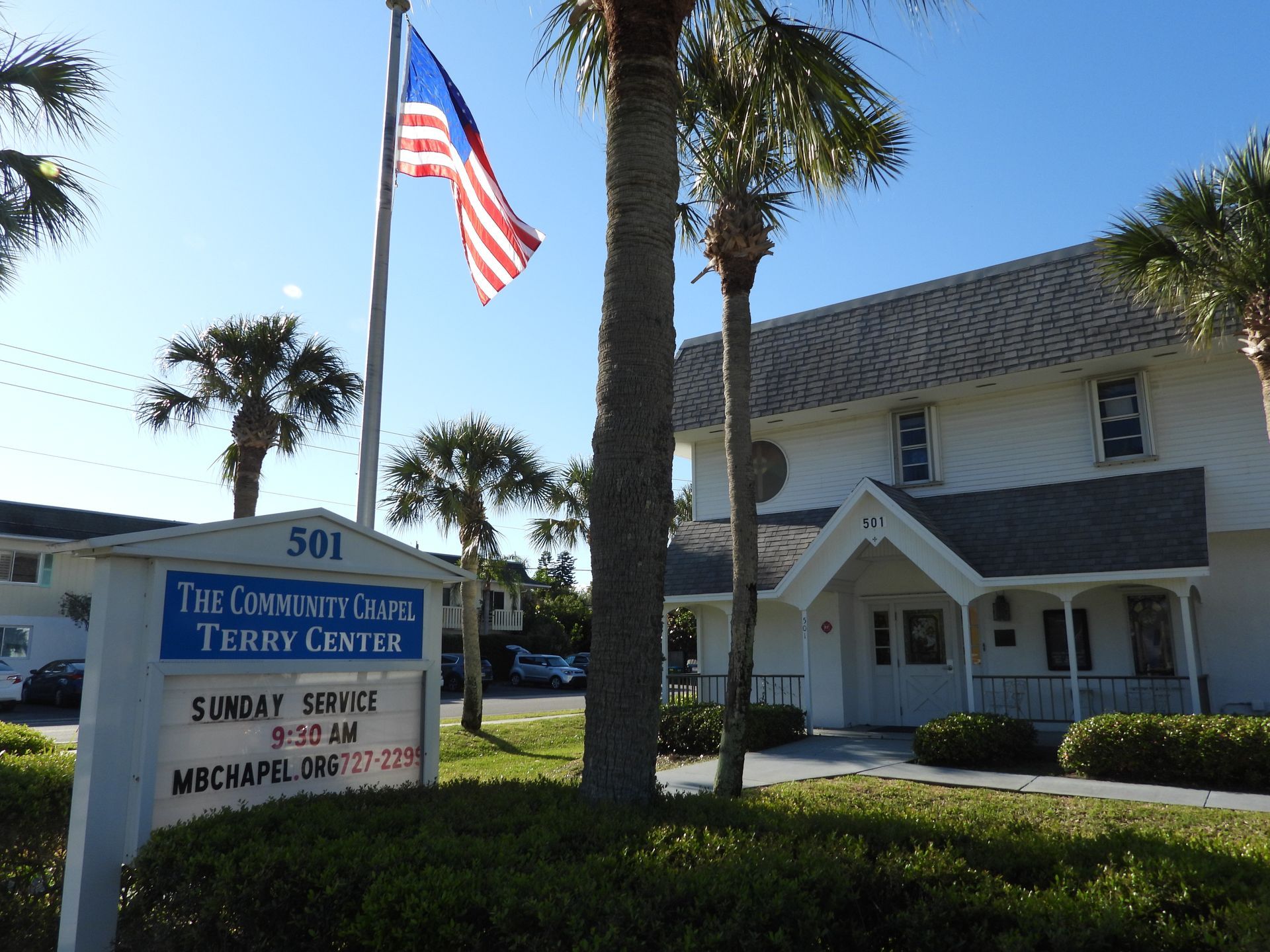 A white building with a sign that says the community center