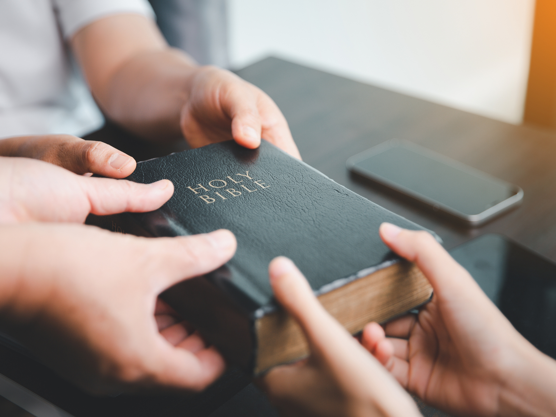 A person is giving a bible to another person.