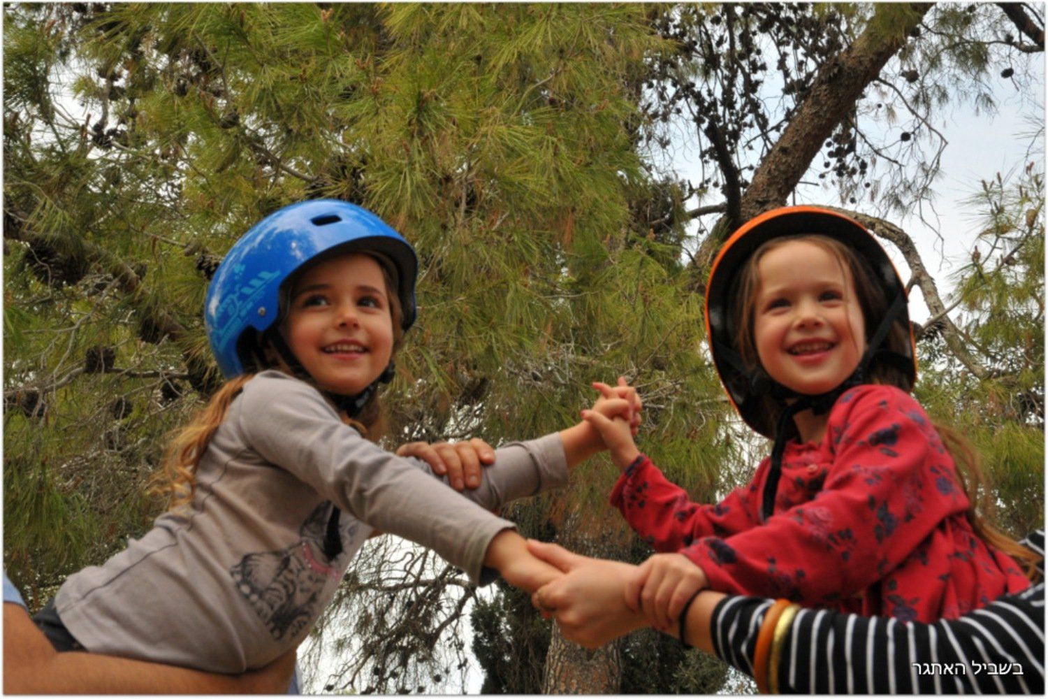 שתי ילדות קטנות חובשות קסדות מחזיקות ידיים