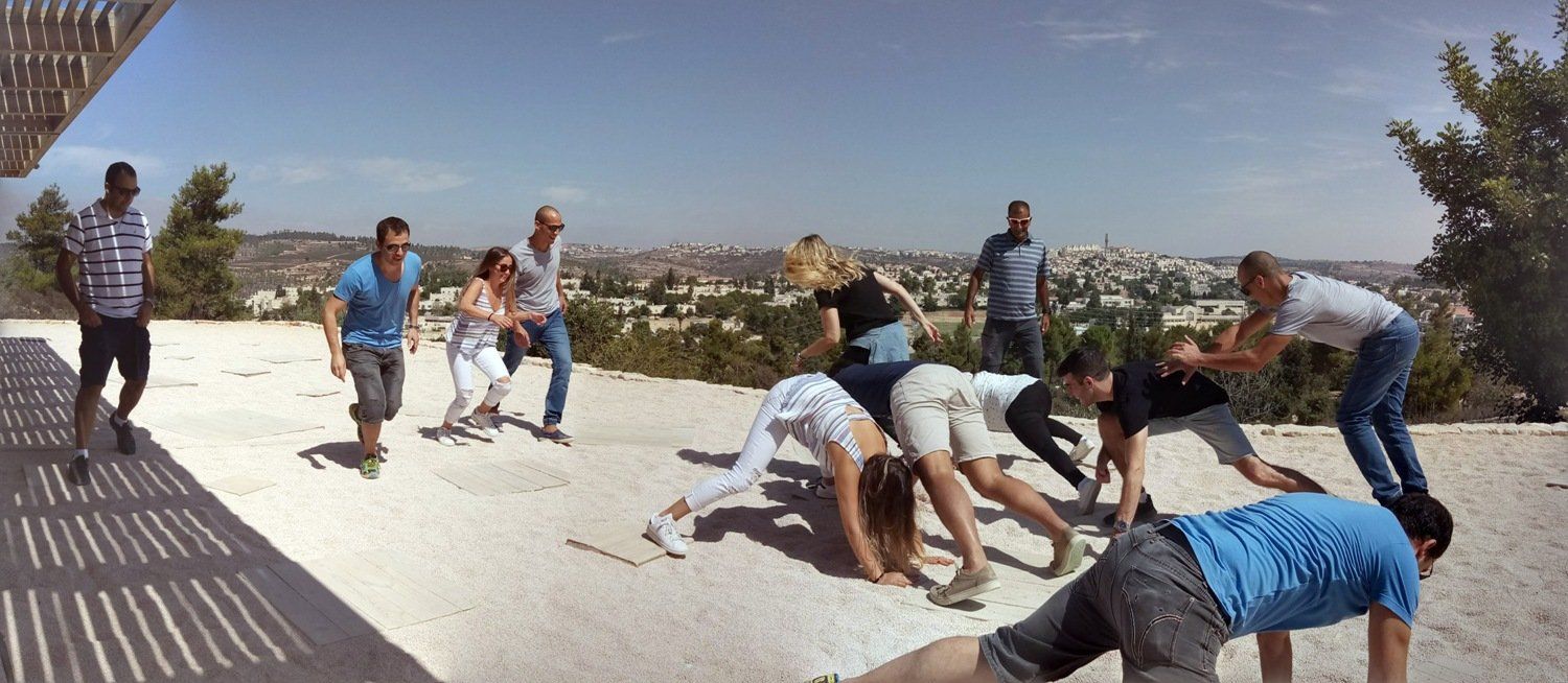 קבוצה של אנשים עומדים זה על זה על גבעה.