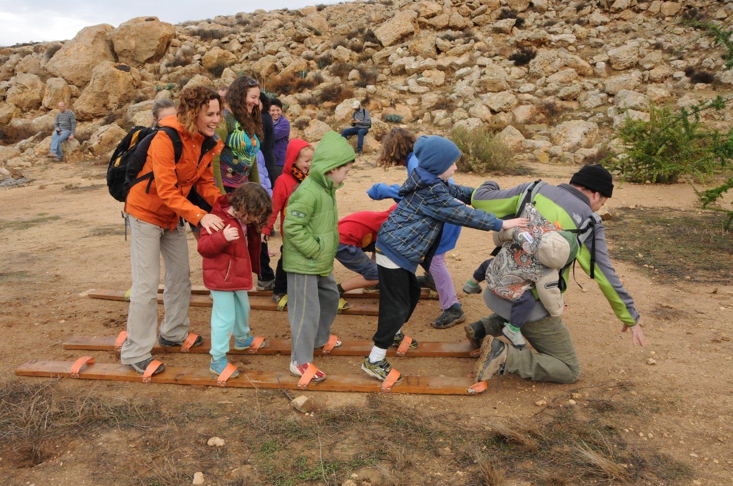 קבוצת ילדים משחקים על סולם עץ.