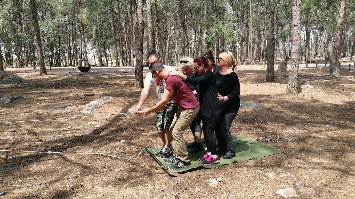 קבוצה של אנשים משחקת משחק ביער.
