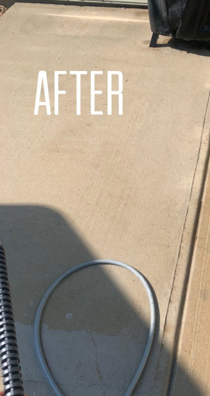 A person is holding a notebook and a hose on a sidewalk.