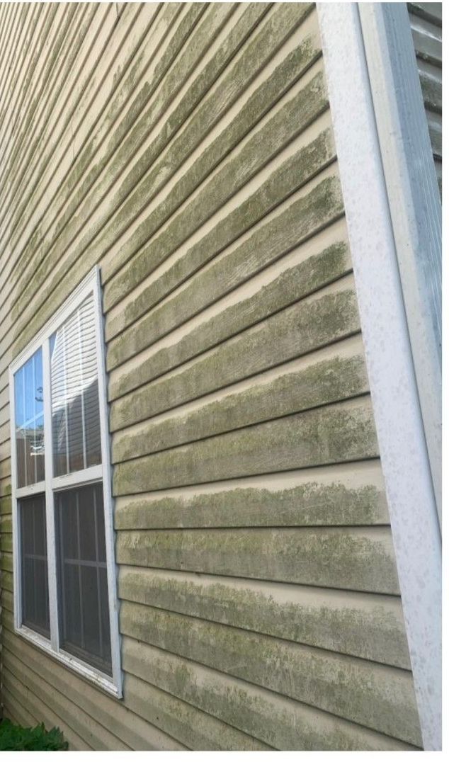 A house with a dirty siding and a window.