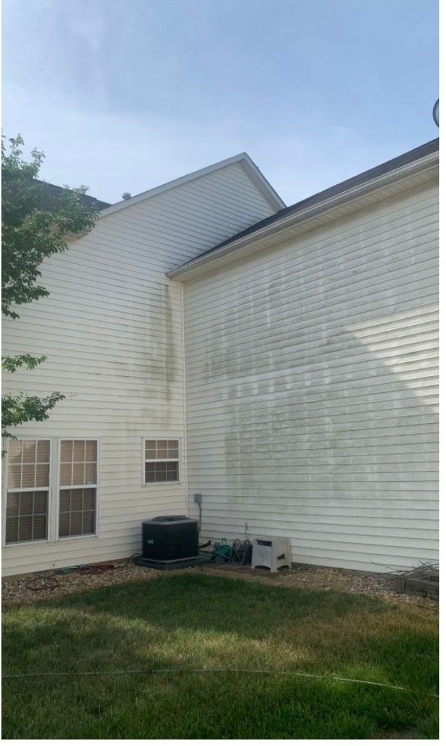 The back of a white house with a lot of stains on it.