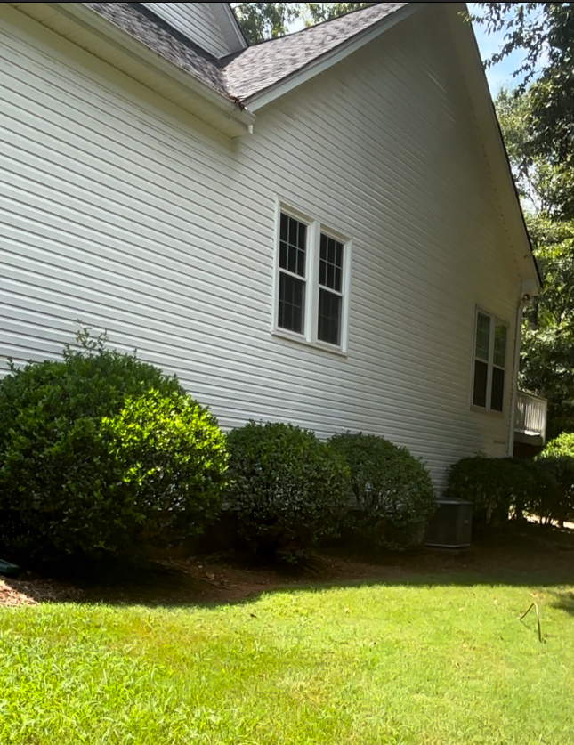 A white house with a lush green lawn in front of it