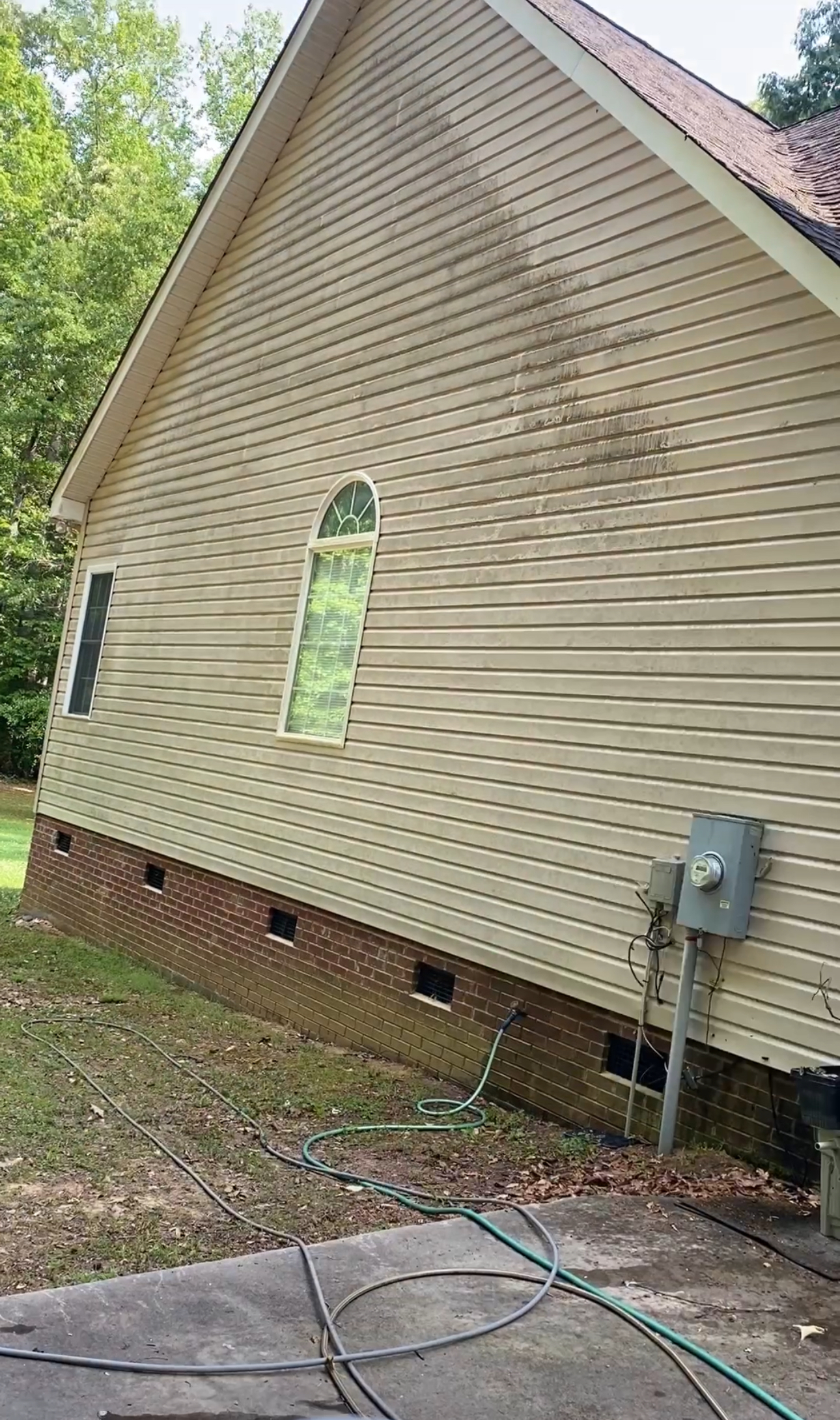 The side of a house with a hose attached to it.