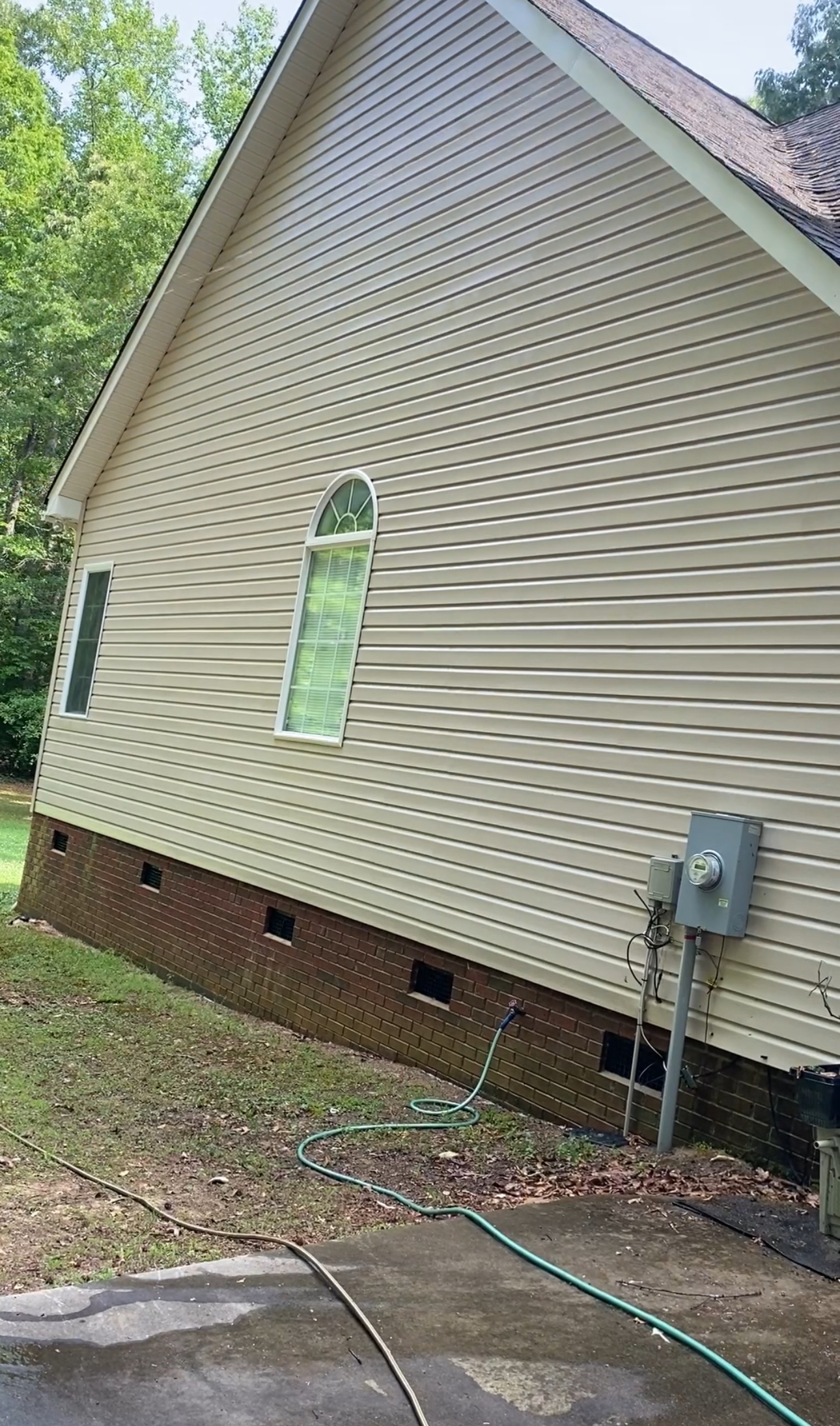 The side of a house with a hose attached to it.