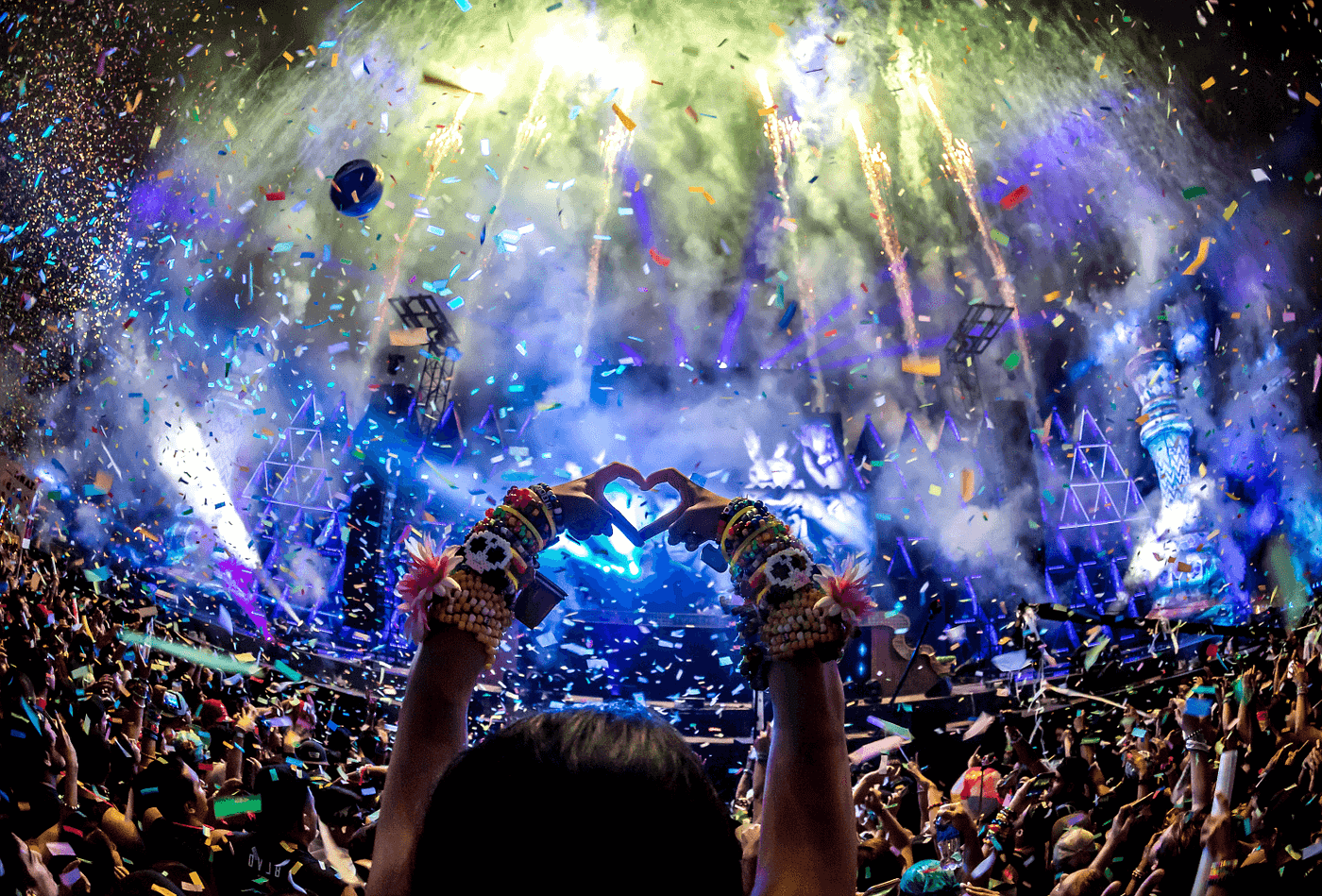 A crowd of people are watching fireworks at a concert.